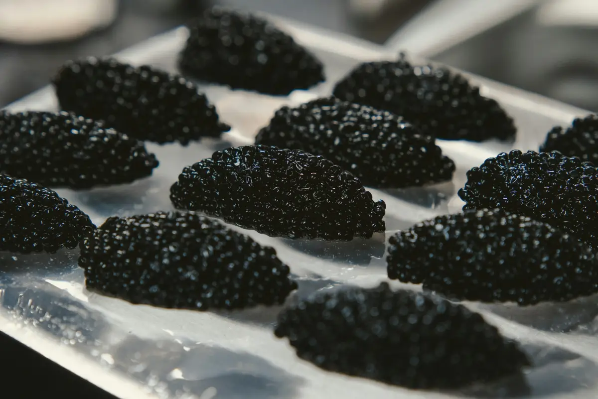 Quenelles of dark caviar on a serving tray